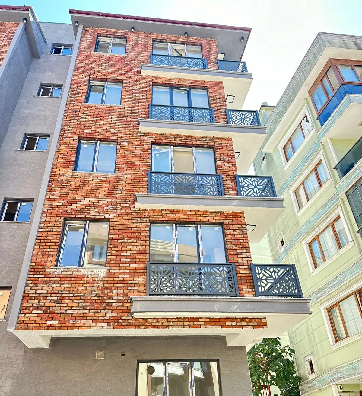 Tuğla kaplamalı apartmanda desenli balkon korkulukları