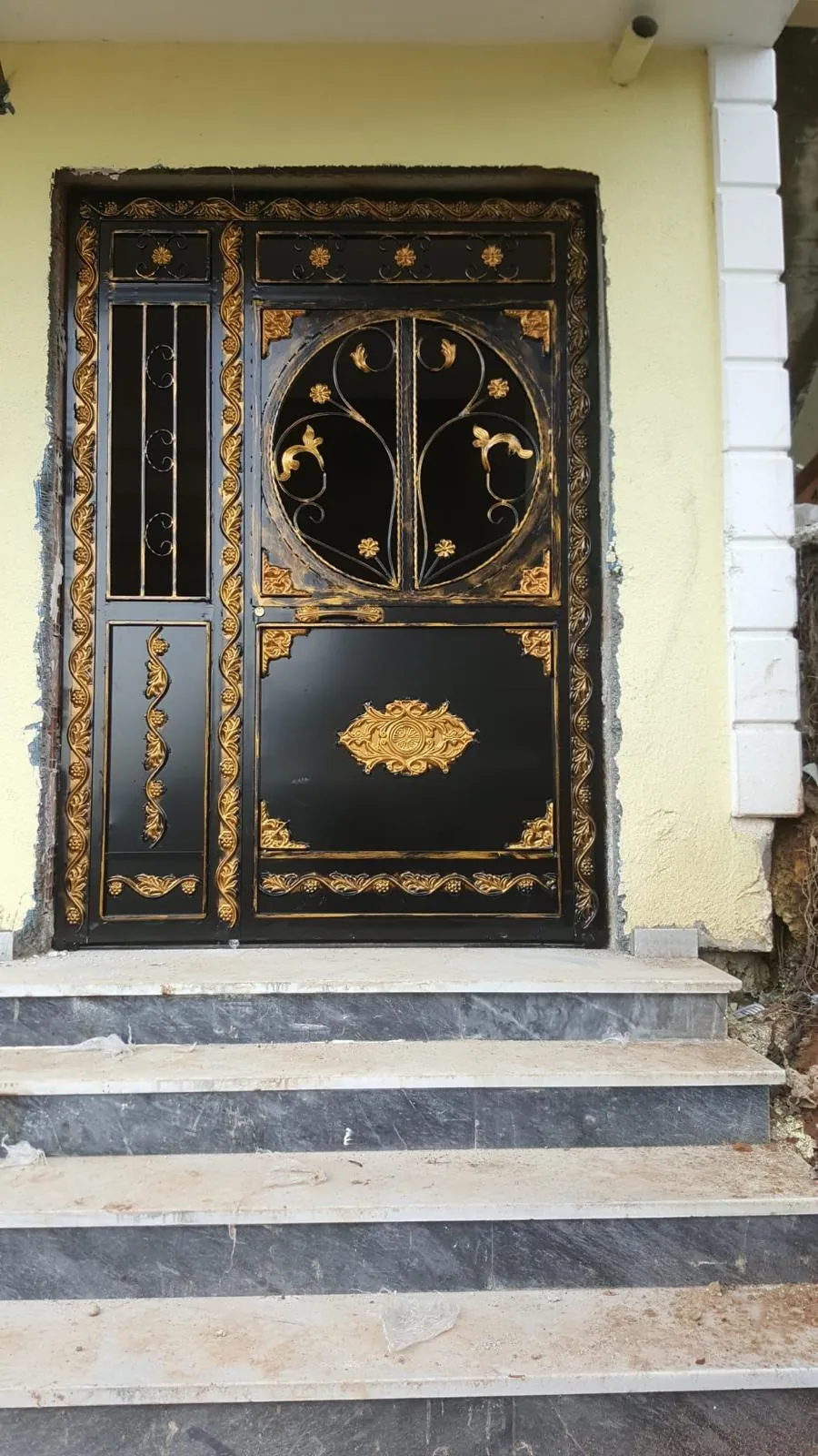 Altın süslemeli siyah bina giriş kapısı